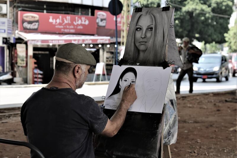 Syrian painter Bassam Hamid,  who makes a meagre living painting portraits, sits under the Cola Bridge in Beirut.  EPA