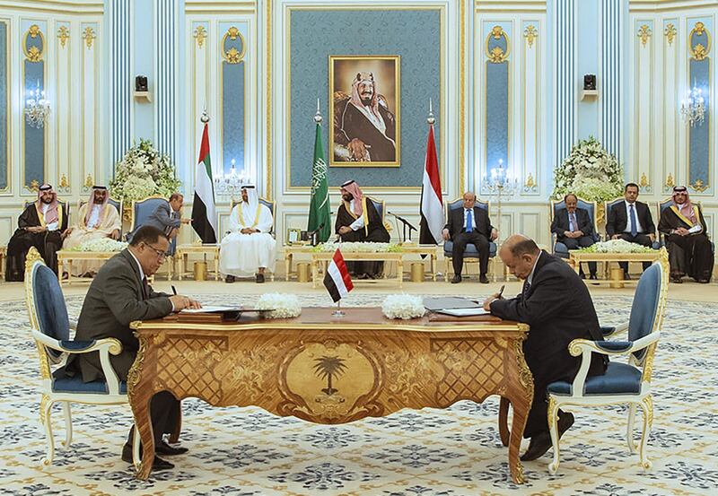 Sheikh Mohamed bin Zayed, Prince Mohammed bin Salman and Mr Hadi watch as Mr Al Khabji and Mr Al Khanbashi sign the power-sharing agreement. AFP