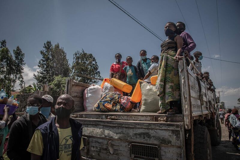 Displaced people who fled Goma after the eruption of the Nyiragongo volcano climb aboard a truck in Sake.