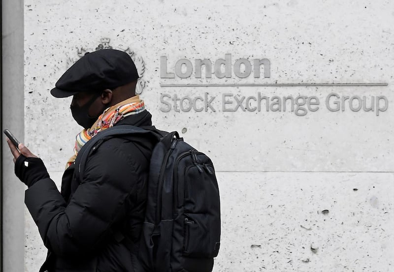 FILE PHOTO: A man wearing a protective face mask walks past the London Stock Exchange Group building in the City of London financial district, whilst British stocks tumble as investors fear that the coronavirus outbreak could stall the global economy, in London, Britain, March 9, 2020. REUTERS/Toby Melville/File Photo