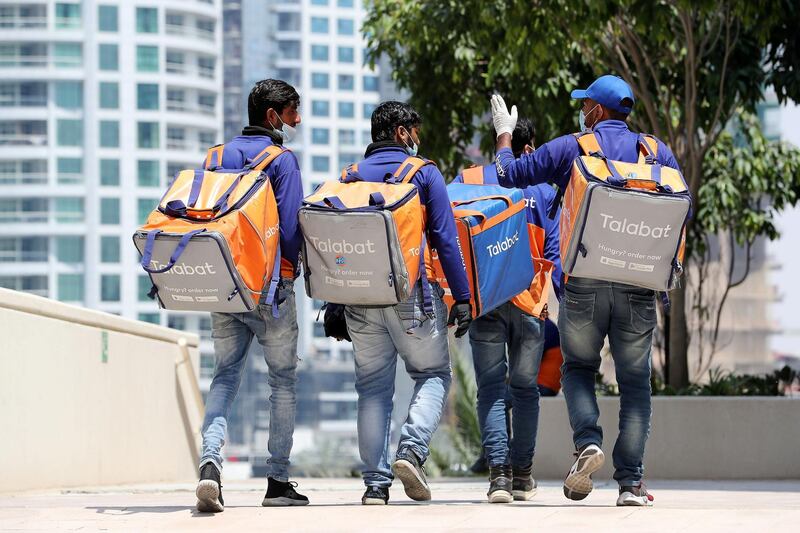 DUBAI, UNITED ARAB EMIRATES , April 17– 2020 :- Talabat delivery guys going to collect their orders in Dubai Marina in Dubai. Dubai is conducting 24 hours sterilisation programme across all areas and communities in the Emirate and told residents to stay at home. UAE government told residents to wear face mask and gloves all the times outside the home whether they are showing symptoms of Covid-19 or not.  (Pawan Singh / The National) For News/Online/Instagram