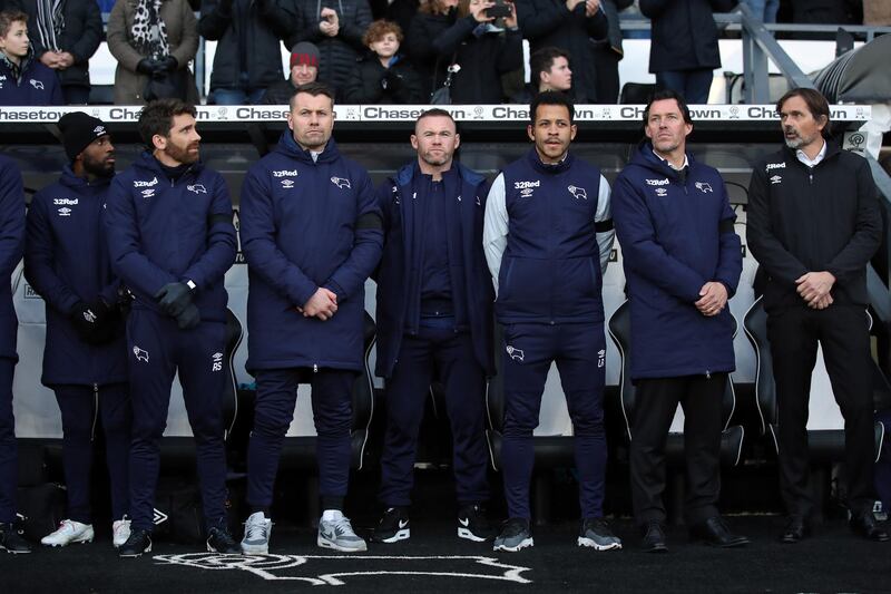 Wayne Rooney, centre, with Shay Given, centre left, and Derby manager Phillip Cocu, right, during the Championship match between Derby County and Millwall at Pride Park Stadium on December 14. Getty Images