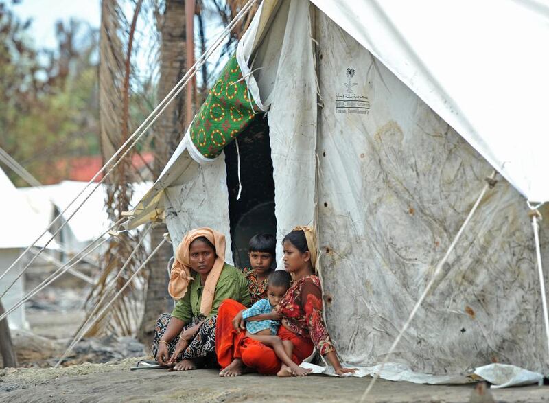 A Rohingya family sits outside a temporary shelter. Soe Than Win / AFP