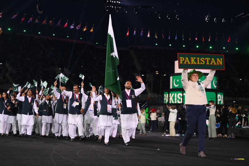 Muhammad Inam and Bismah Maroof, flag bearers for Pakistan, usher their teammates on to Alexander Stadium. Getty