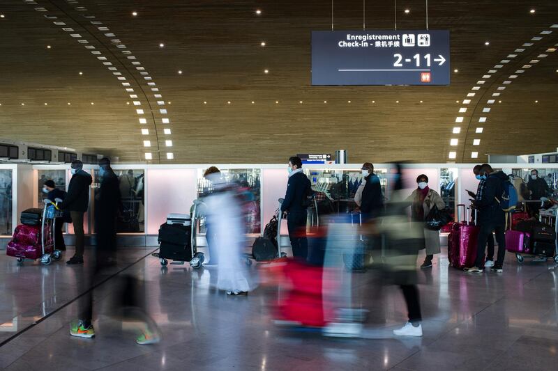 Travelers pass through the check-in hall at Charles de Gaulle airport, operated by Aeroports de Paris, in Roissy, France, on Friday, Dec. 18, 2020. The rollout of vaccines against Covid-19 has intensified debate about whether they should be made mandatory, with the head of a major tourism lobby saying that doing so would cause irreparable harm to the struggling sector. Photographer: Nathan Laine/Bloomberg via Getty Images
