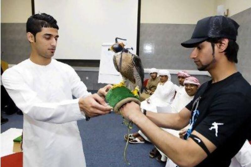 Yousif Albloushi, 18, left, and Khalid Alkaabi, 19, take turns holding a falcon during a field studies course that exposes students to the ecology of Fujairah. Sarah Dea / The National