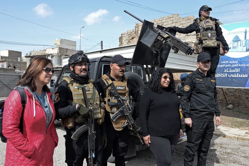 Tourists pose for a picture with member of the Iraqi security forces in the northern city of Mosul.