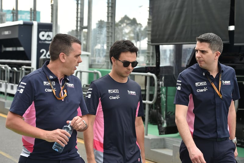 Racing Point's Mexican driver Sergio Perez (C) walks down pit lane at the Albert Park circuit ahead of the Formula One Australian Grand Prix in Melbourne.  AFP