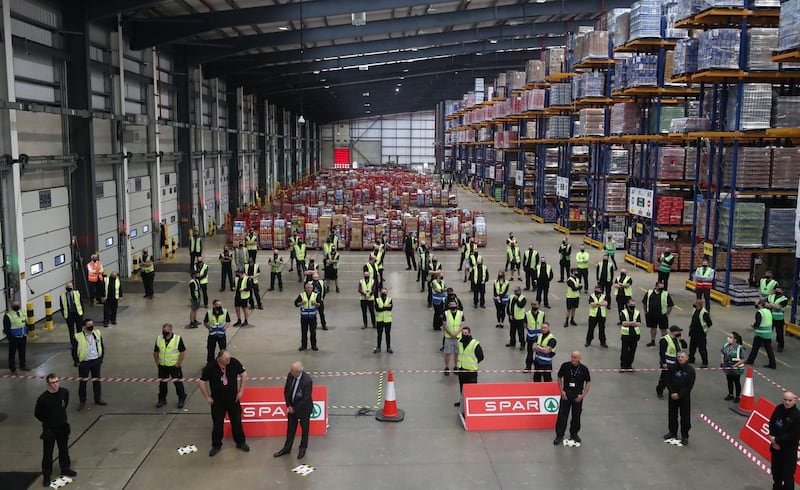 Staff at Henderson Foodservice's food and grocery distribution centre stand socially distanced as they await the arrival of Britain's Prince Charles in Newtownabbey, near Belfast. AFP