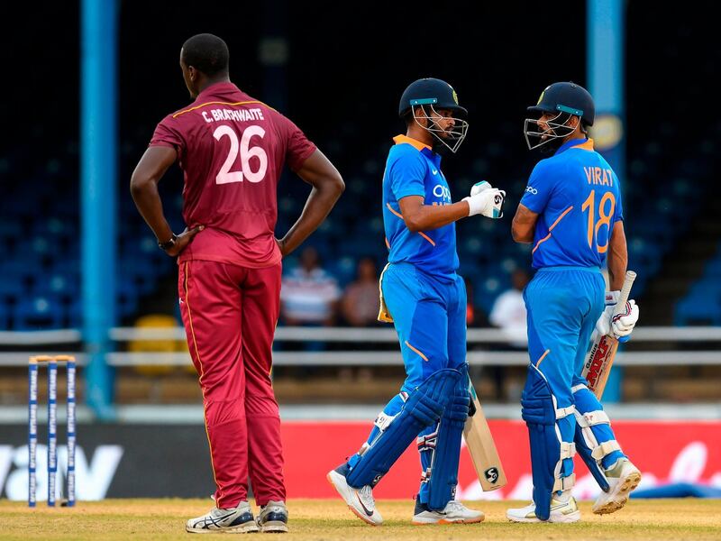 Shreyas Iyer (C) and Virat Kohli (R) of India celebrate 50 partnership as Carlos Brathwaite (L) of West Indies expresses disappointment during the 3rd ODI match between West Indies and India at Queens Park Oval, Port of Spain, Trinidad and Tobago, on August 14, 2019.  / AFP / Randy Brooks
