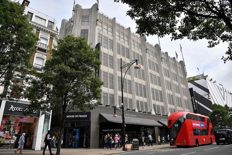 Pedestrians walk past the entrance to House of Fraser department store on Oxford Street in London on June 7, 2018. Britain's department store chain House of Fraser, majority owned by Chinese conglomerate Sanpower, announced Thursday that it will close more than half of its branches in a rescue deal that places 6,000 jobs at risk. House of Fraser, which has suffered from high costs and fierce online competition, said in a statement that it will shutter 31 of its 59 stores in the UK and Ireland. / AFP / Ben STANSALL
