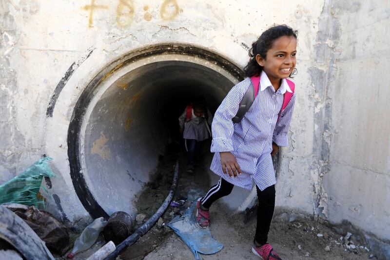 A Palestinian Bedouin student walks to school through a water tunnel in Khan al-Ahmar, located between the West Bank city of Jericho and Jerusalem near the Israeli settlement of Maale Adumim. Khan al-Ahmar is a Bedouin community where some 180 people live in shacks, which Israeli authorities claim were built without obtaining permits. EPA