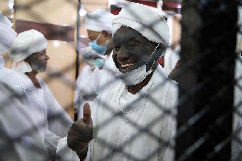 Former Sudanese vice president Ali Ossman Taha gestures behind bars during the trial of ousted Sudanese president Omar al-Bashir and over two dozen former top officials, in Khartoum, Sudan. AP