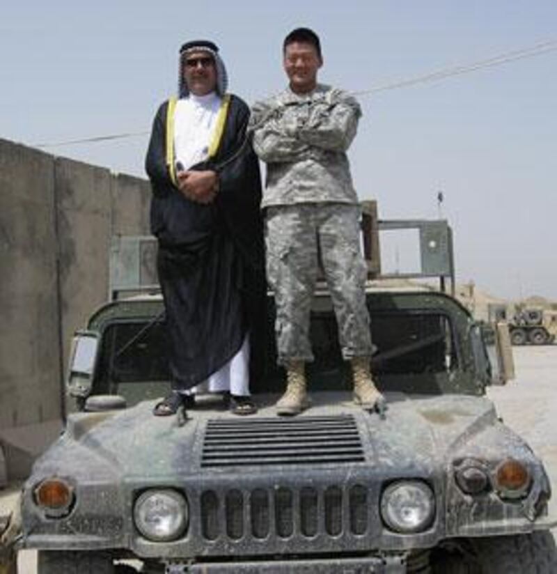 Lt Dan Choi, who came out as gay in March and was subsequently dismissed from the US army, stands on the bonnet of a Humvee in south Baghdad with an Iraqi sheikh.