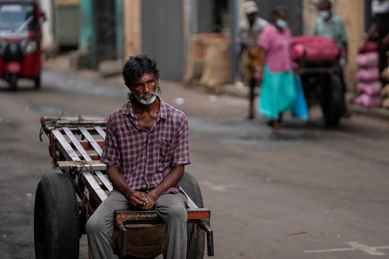A daily wage labourer waits for work at a market in Colombo, Sri Lanka. Sri Lankans have endured months of shortages of food, fuel and other necessities because of the country's dwindling foreign exchange reserves and mounting debt, worsened by the coronavirus pandemic and other, longer-term troubles. AP