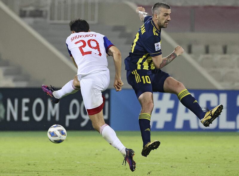 Sharjah's midfielder Otabek Shukurov, left, battles for the ball with Pakhtakor's forward Dragan Ceran. AFP