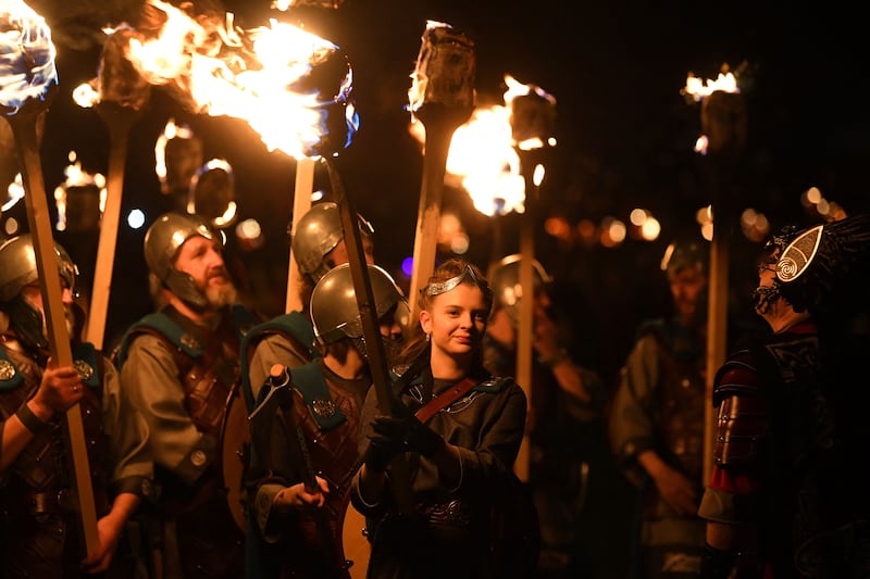 Members of the Up Helly Aa 'Jarl Squad' parade through the streets of in Lerwick, Shetland Islands on January 30, 2024 during the Up Helly Aa festival later in the day.  Up Helly Aa celebrates the influence of the Scandinavian Vikings in the Shetland Islands and culminates with up to 1,000 'guizers' (men in costume) throwing flaming torches into their Viking longboat and setting it alight later in the evening.  (Photo by ANDY BUCHANAN  /  AFP)