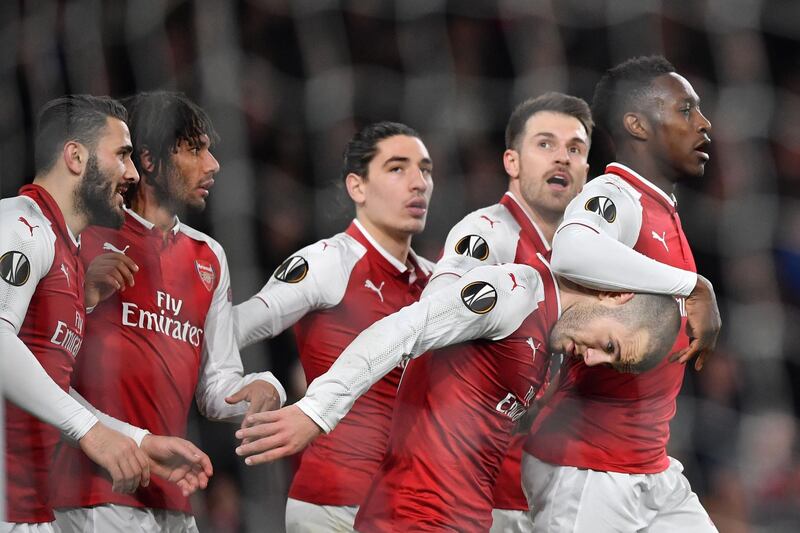 TOPSHOT - Arsenal's English striker Danny Welbeck (R) celebrates with teammates scoring the team's third goal during the UEFA Europa League round of 16 second-leg football match  between Arsenal and AC Milan at the Emirates Stadium in London on March 15, 2018.  / AFP PHOTO / Ben STANSALL