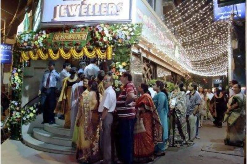 Buyers stand in a queue outside a jewelry shop during Dhanteras festival in Calcutta, India, Wednesday, Nov. 3, 2010. Hindus consider it auspicious to purchase gold, silver and utensils during Dhanteras, which marks the beginning of the five-day Diwali festival.