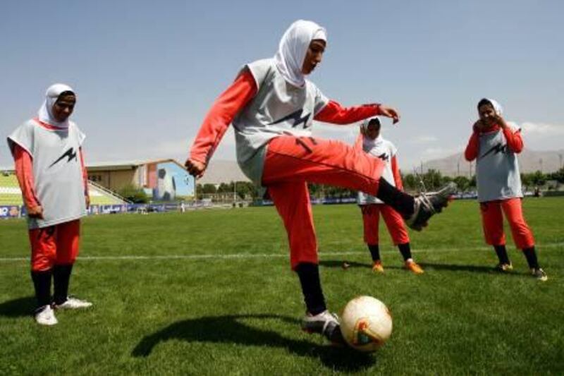 Players of Iran's women national football team warm-up before their friendly football match with club Malavan Anzali women's team in Tehran on June 25, 2009. The head of Iran's football federation has denied punishing players for wearing green wristbands in a show of support of the opposition during a World Cup qualifier, local media reported. AFP PHOTO/ISNA/AMIR POORMAND