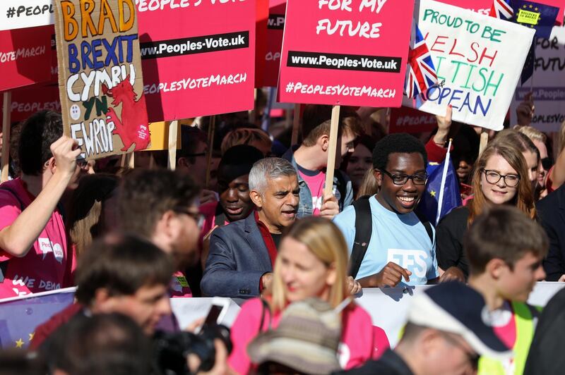 Sadiq Khan, London's mayor, center, stands with demonstrators holding signs during the anti-Brexit People's Vote march, in London, U.K., on Saturday, Oct. 20, 2018. U.K. Prime Minister Theresa May is said to be ready to ditch one of her key Brexit demands in order to resolve the vexed issue of the Irish border and clear the path to a deal, according to people familiar with the matter. Photographer: Chris Ratcliffe/Bloomberg