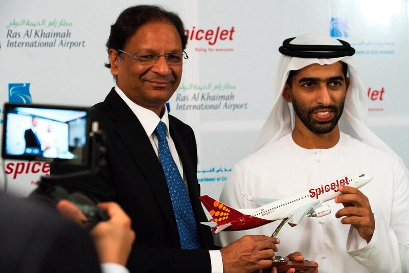 SpiceJet chairman and managing director Ajay Singh, left, and Sheikh Khalid bin Saud Al Qasimi, a son of Ras al-Khaimah ruler Sheikh Saud bin Saqr Al Qasimi, right, pose for photographs during a news conference in Ras al-Khaimah, United Arab Emirates, Wednesday, Oct. 23, 2019. India's low-cost airline SpiceJet announced plans Wednesday to build its first international hub in the United Arab Emirates, offering a pledge of support to Boeing Co. by saying it would use now-grounded 737 MAX aircraft in the operation once regulators approve the planes for flight. (AP Photo/Jon Gambrell)