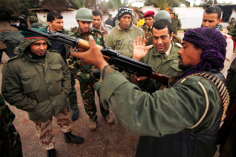 A rebel army officer teaches the use of weapons to civilians who have volunteered to join the rebel army in Benghazi February 27, 2011. The rebel army is preparing to fight Libyan leader Muammar Gaddafi's forces in Tripoli if necessary, an official in the rebel army said. REUTERS/Suhaib Salem (LIBYA - Tags: POLITICS CIVIL UNREST MILITARY)