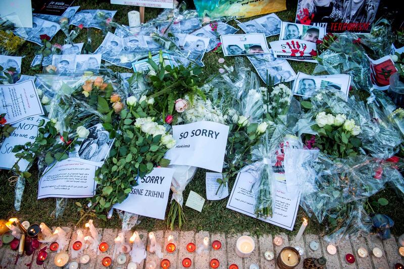 This picture shows texts, pictures and candles laid down as Moroccans pay tribute to murdered Danish Louisa Vesterager Jespersen and Norwegian Maren Ueland in Rabat, in front the Norwegian ambassy on December 22, 2018. Crowds of Moroccans gathered on December 22 to mourn two Scandinavian hikers brutally murdered by suspected jihadists in the High Atlas mountains. Hundreds of people paid tribute to Danish student Louisa Vesterager Jespersen, 24, and 28-year-old Norwegian Maren Ueland outside the embassies of their homelands in the capital Rabat. / AFP / FADEL SENNA

