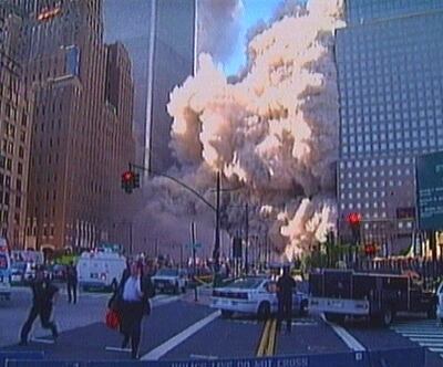 Pedestrians and police run as a tower of the World Trade Center collapses, after two planes crashed into the complex destroying New York's twin towers on September 11, 2001. Reuters