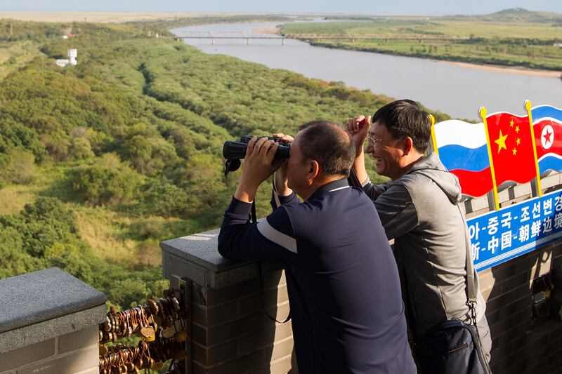 In this Saturday, Sept. 9, 2017 photo, a man looks through a binocular at an observation post near the border between North Korea and China, in Yanbian in China's Jilin province. The United States has called for a vote Monday on a U.N. resolution that would impose the toughest-ever sanctions on North Korea and could lead to a showdown with the country's biggest trading partner China and its neighbor Russia. (AP Photo)