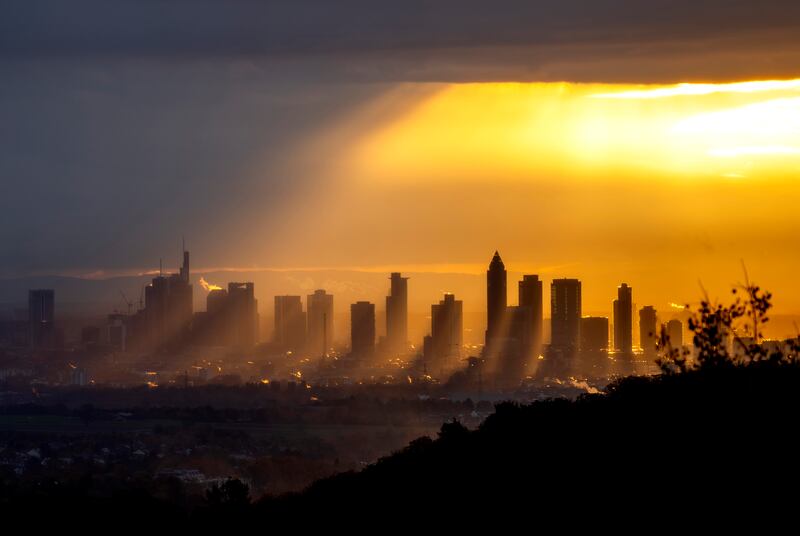 Sunrays shine through the clouds over buildings in the central banking district of Frankfurt, Germany. AP