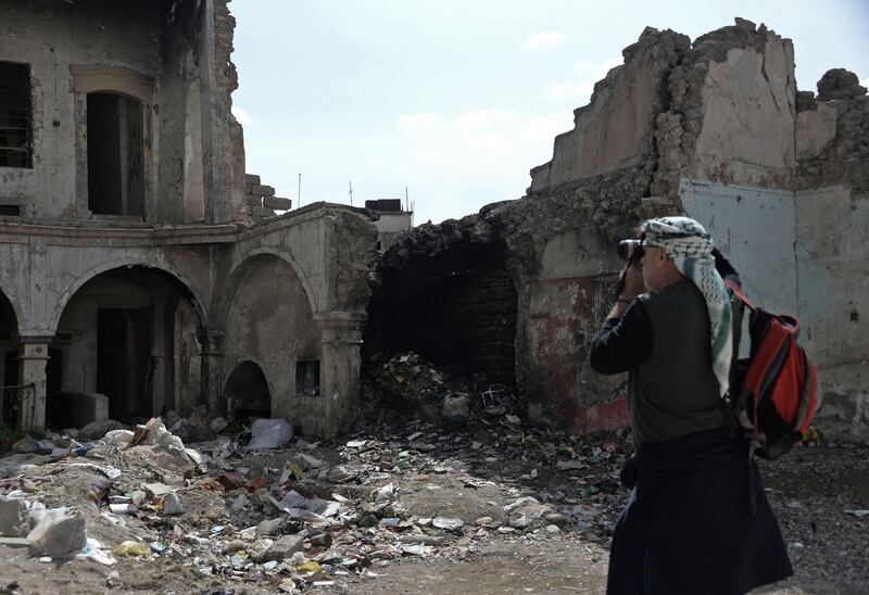 A tourist shoots photos of the destruction caused by years of conflict in the northern Iraqi city of Mosul.