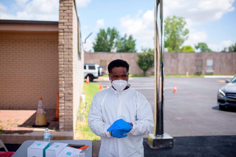 A healthcare worker puts on additional personal protective equipment at a COVID-19 testing site at United Memorial Medical Center in Houston, Texas, on July 9, 2020. / AFP / AFP  / Mark Felix
