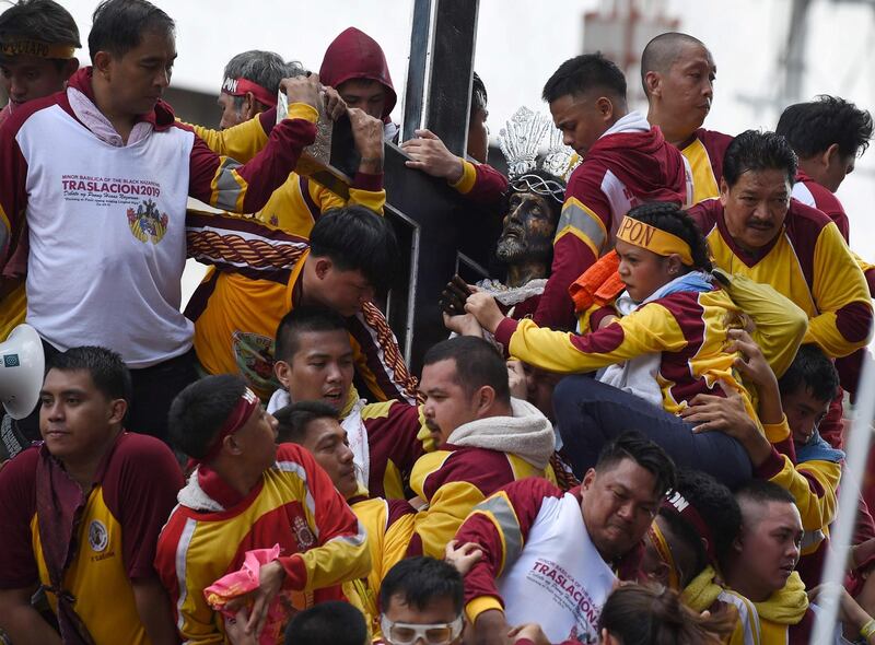Catholic devotees jostle with each other as they try to touch the Black Nazarene statue on a carriage during the annual religious procession in honour of the Black Nazarene in Manila on January 9, 2019. Throngs of believers flung themselves at a historic statue of Jesus Christ as it inched through Manila on January 9 for an annual procession that is one of the world's biggest shows of Catholic zeal.
 / AFP / TED ALJIBE
