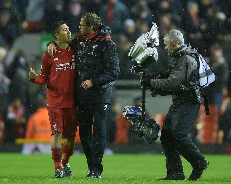 Liverpool’s midfielder Roberto Firmino of Brazil (L) and manager Jurgen Klopp (2-L) embrace after drawing 3-3 with Arsenal during their English Premier League soccer match at Anfield, Liverpool, Britain, 13 January 2016.  EPA/PETER POWELL