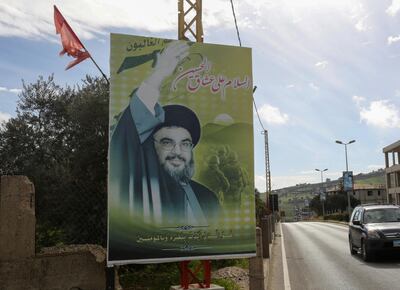 A car drives past a poster depicting Lebanon's Hezbollah leader Sayyed Hassan Nasrallah in Bint Jbeil, southern Lebanon February 16, 2021. REUTERS/Aziz Taher