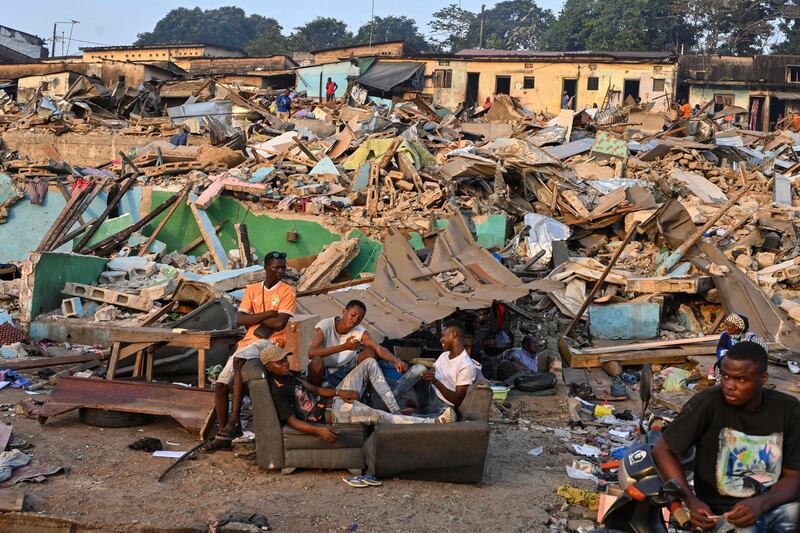 Evicted residents gather in the street with their belongings after the demolition of their house in Abidjan, Ivory Coast. AFP