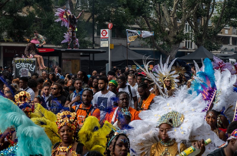 Performers and revellers dance in the street during the Notting Hill Carnival in London on Monday. Getty