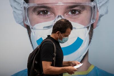 A man wearing a face mask to prevent the spread of coronavirus walks in the Vallecas neighborhood in Madrid, Spain, Saturday, Sept. 19, 2020. Authorities in Madrid, the European capital experiencing the worst second-wave outbreak, are introducing new curbs on social gatherings starting Monday. (AP Photo/Manu Fernandez)