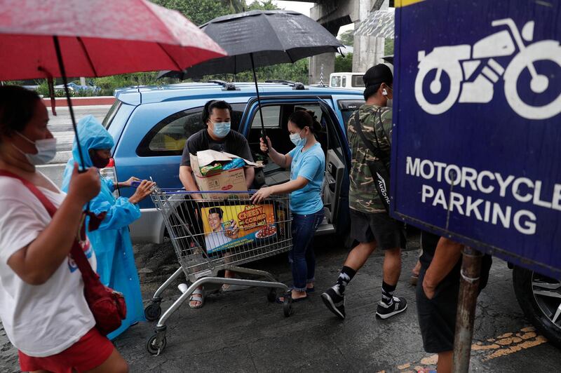 A man carries groceries as residents prepared for a return to lockdown measures in Quezon City, Philippines on Monday. AP Photo