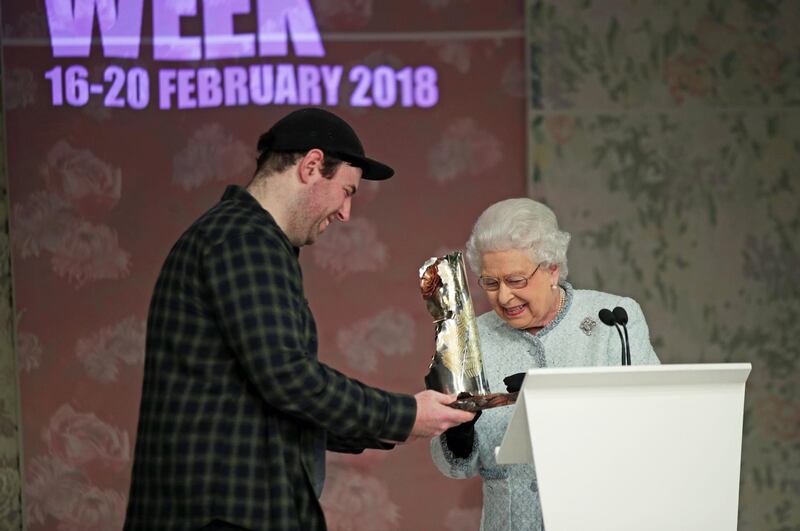 Queen Elizabeth II presents Richard Quinn with the inaugural Queen Elizabeth II Award for British Design on February 20, 2018 in London. Getty Images