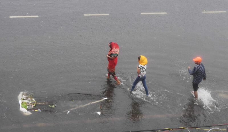 Indian residents wade along a partially flooded street after Cyclone Fani landfall in Puri. AFP