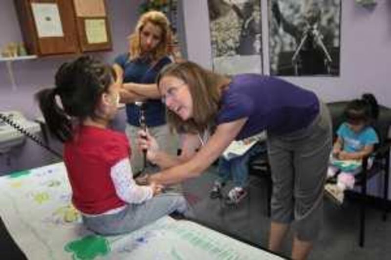 AURORA, CO - JULY 28: Physician's Assistant Kim Gracey checks the throat of Joselyn Mejia, age 4, suffering from a stomach ache at the low-cost Rocky Mountain Youth Clinic on July 28, 2009 in Aurora, Colorado. The mother Jessica Mejia, in background, said she has health insurance through her employer, but finds the clinic cheaper than paying the deductible to have her children cared for by a family practitioner. Funded primarily through donations and grants, Rocky Mountain Clinics treats mostly children of uninsured parents, those on medicaid and others who's parents cannot afford to pay the high deductibles charged by many health insurance policies.   John Moore/Getty Images/AFP