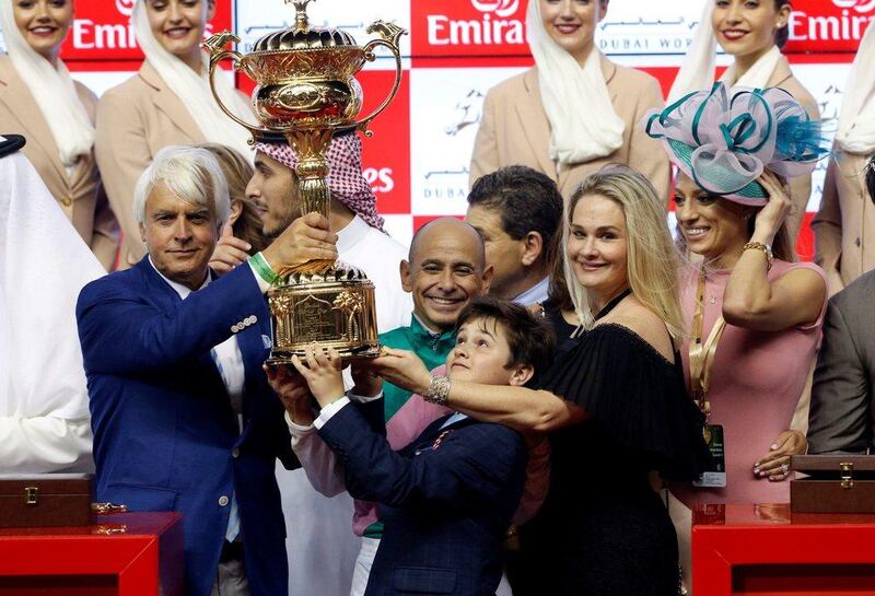 Arrogate trainer Bob Baffer, left, and jockey Mike Smith centre, lift the Dubai World Cup following Arrogates victory at Meydan Racecourse. Ahmed Jadallah / Reuters