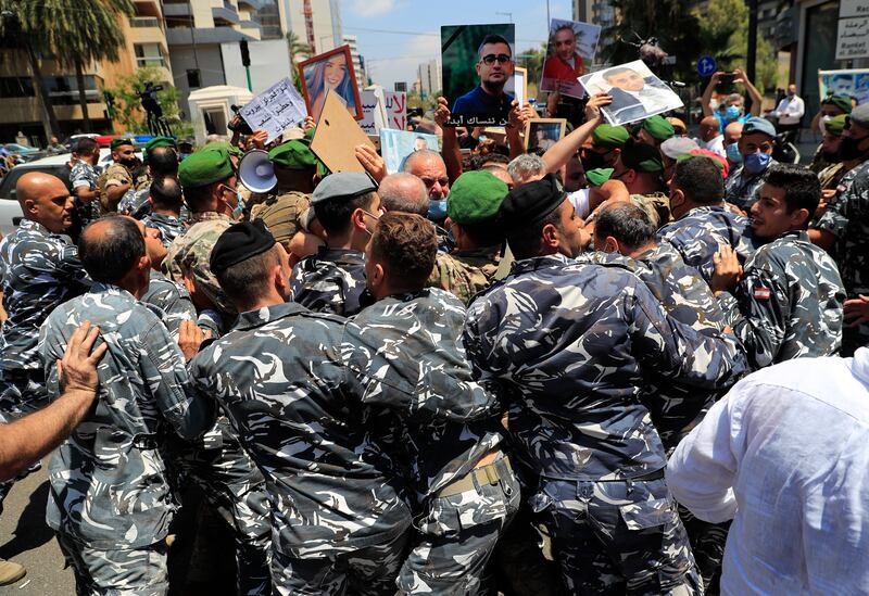 The private security forces of parliament speaker Nabih Berri push back the families of the victims of last year's massive blast at Beirut's port, as they protest and try to reach his tightly-secured residence, in Beirut, Lebanon, on July 9, 2021.  AP