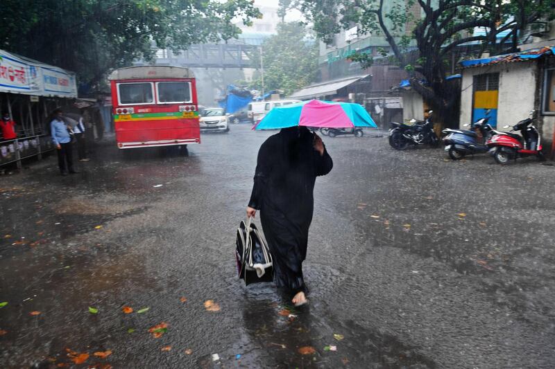 A woman walks along a road in Mumbai, India, after Cyclone Tauktae caused heavy rain. AFP
