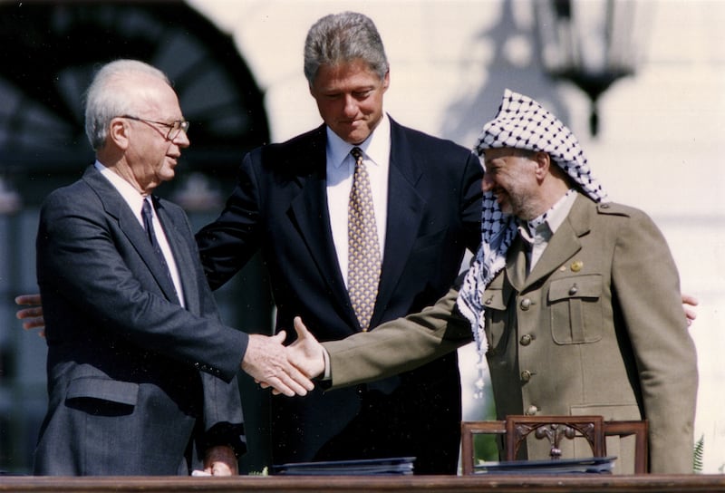 From right, PLO chairman Yasser Arafat shakes hands with Israeli leader Yitzhak Rabin as Bill Clinton looks on after the signing of the Oslo Peace Accords on September 13, 1993. Reuters