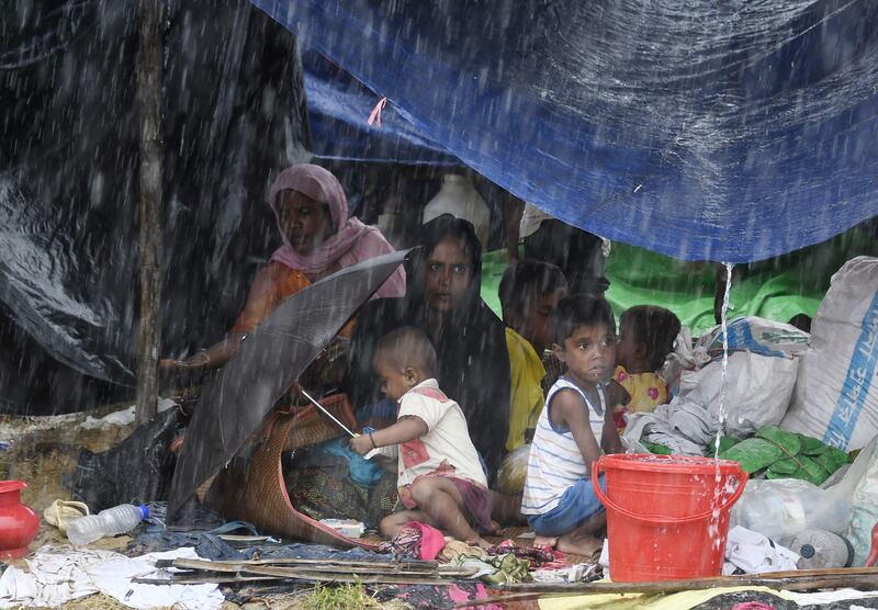 Rohingya refugees sit under a shelter during rainfall at Thangkhali refugee camp in Bangladesh's Cox's Bazar district. Dominique Faget / AFP Photo