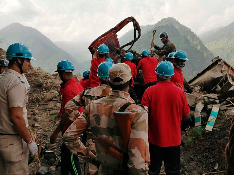 Rescuers at the site of a landslide in India's northern state of Himachal Pradesh. The landslide in Kinnaur district buried vehicles under debris, killing several people.