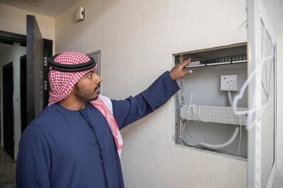 AJMAN, UNITED ARAB EMIRATES. 16 MAY 2019. Four years after they moved in, residents and apartment owners at Paradise Lake Towers are still waiting for their internet connection to be installed. The buildings are still also not connected to the electrical grid and several apartments face severe construction quality issues. Apartment owner Khaled Salem in his apartment where he shows the empty internet supplu cable box that is still empty.. (Photo: Antonie Robertson/The National) Journalist: Ruba Haza. Section: National.